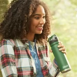 Mujer sonriendo con Botella Térmica Coleman Acero Inox Switch 700ml - Heritage Green