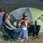 Pareja sentados delante de carpa en Sillas Coleman Director Breeze Steel Deck 136 Kg