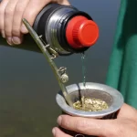 Mano cebando mate con Termo Coleman Acero Inox Matero 360 700ml - Black Sand