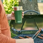 Hombre en la parrilla con Vaso Térmico Coleman Brew Acero Inoxidable 600 Ml - Heritage Red