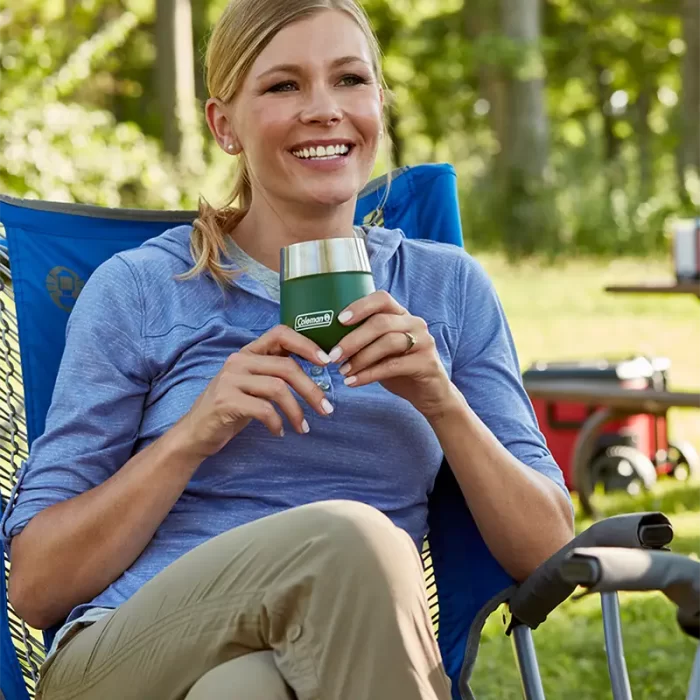 Mujer sentada en un parque con Vaso Termico Coleman Claret 384ml - Black Sand